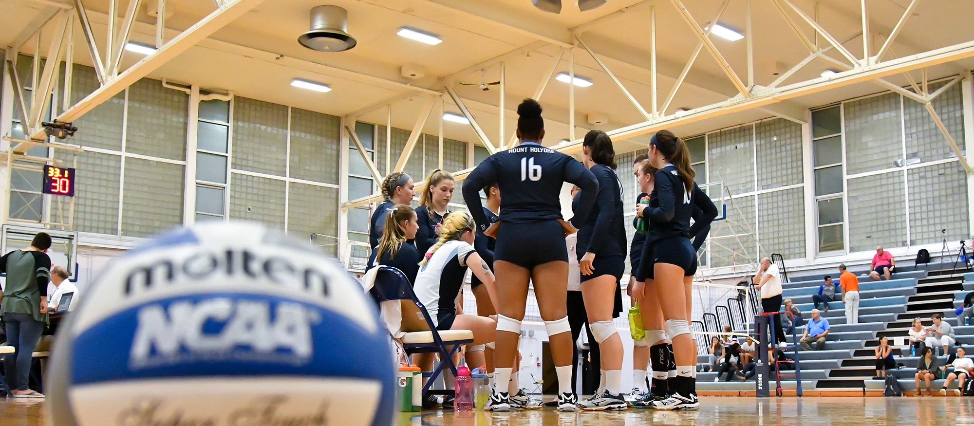 Photo featuring a team huddle during timeout during a 2017 Lyons volleyball game.