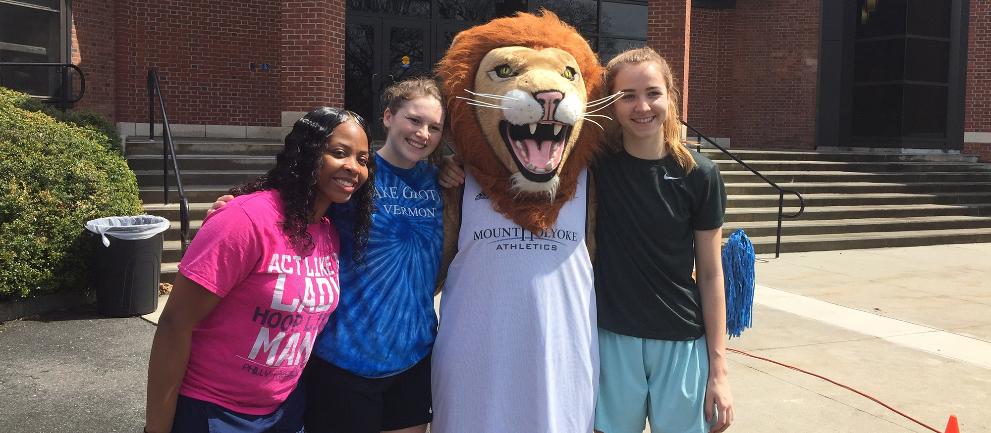 Photo featuring Lyons basketball players, Zahkeyah Allen, Katlyn Grover, PAWS (the Lyons' official mascot) and Annika Brooks.