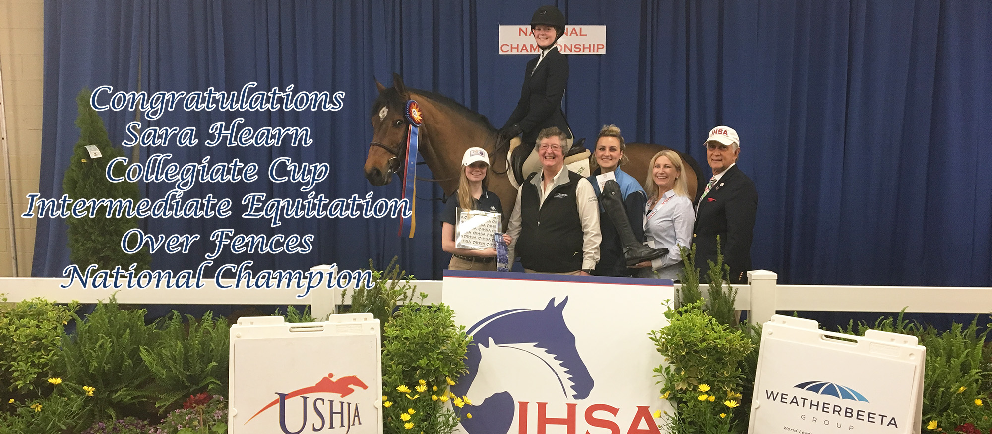 Photo showing Lyons first year rider Sara Hearn, who won the 2018 IHSA Collegiate Cup Intermediate Over Fences Equitation. She is pictured on the winning horse, along with head coach CJ Law, assistant coach Tara Matthews and IHSA Executive Director, Bob Cacchione.