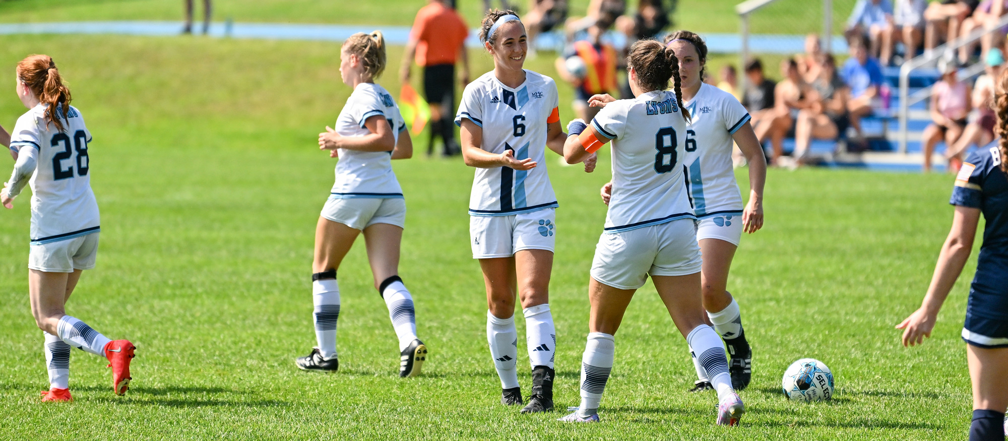 Sonia McCollum (6) congratulates fellow captain Anna Kennedy (8) after Kennedy scored the first of her two goals on penalty kicks during Mount Holyoke's 5-0 win over Massachusetts Maritime on Sept. 4, 2023. (Bob Blanchard/RJB Sports)