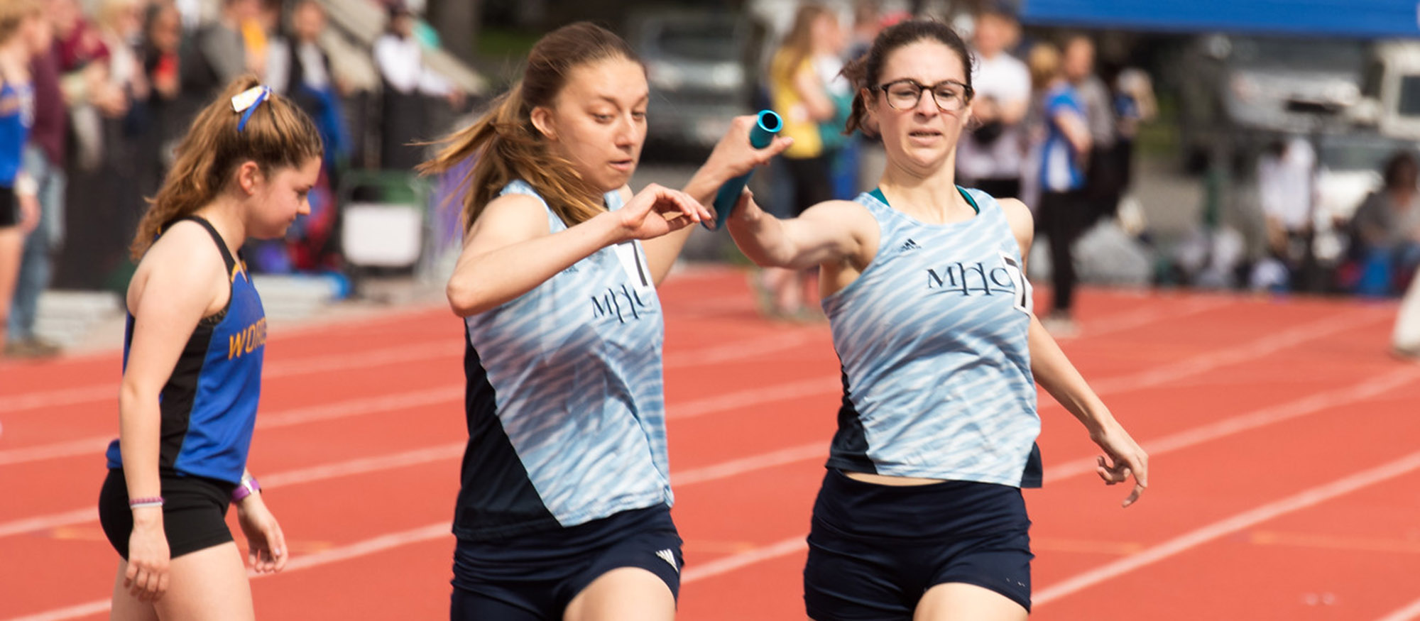 Action photo of seniors Corrin Moss and Emsie Cronin passing the baton in the 4x800 relay. Photo courtesy of J. Cronin - outrageousphotography.net