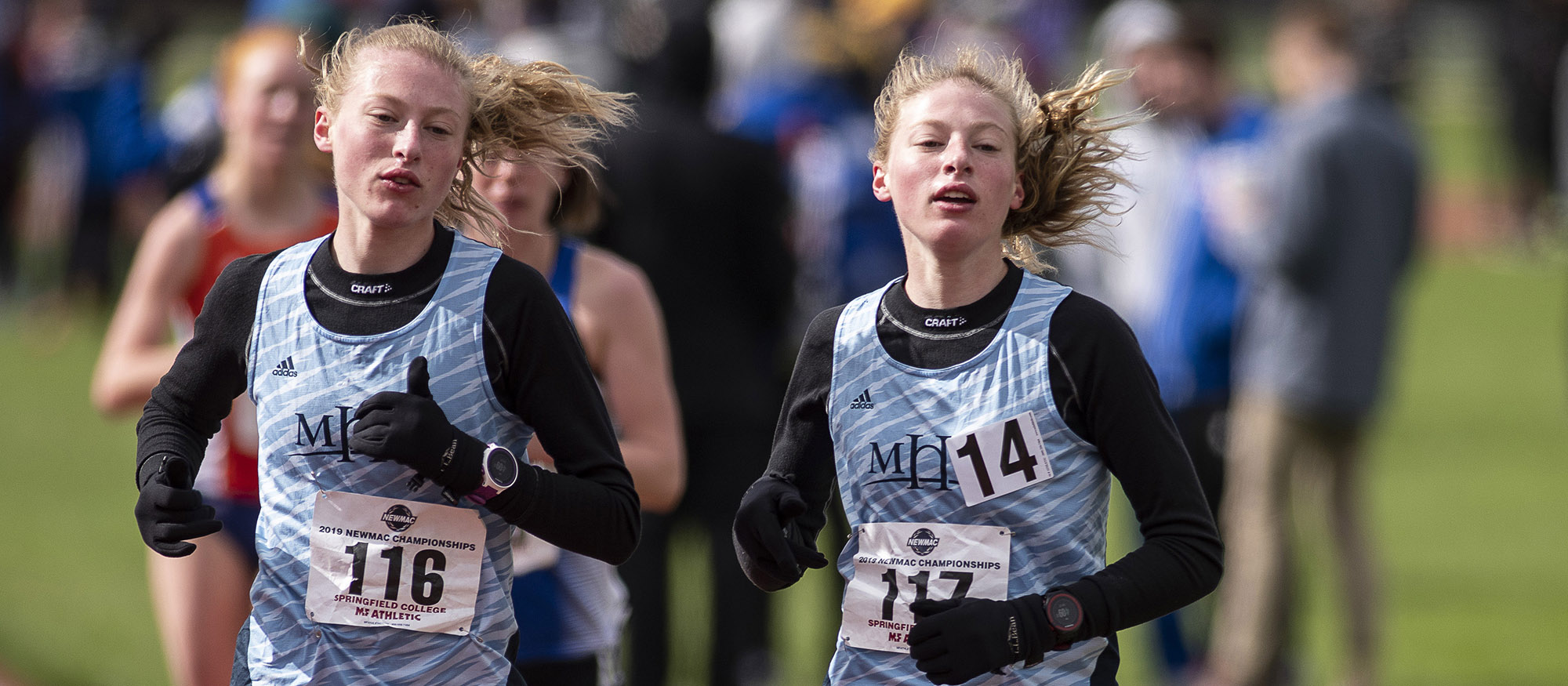 Action photo of Hannah and Madeline Rieders in the 10,000-meter run at the 2019 NEWMAC Championships. Photo courtesy of Frank Poulin.
